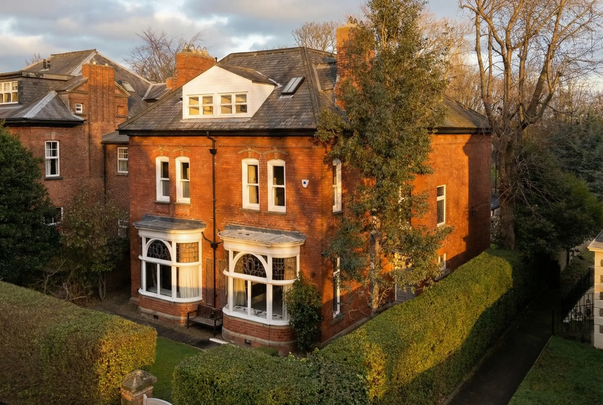 Victorian-style red brick terrace with high-elevation perspective and gilded window soul.