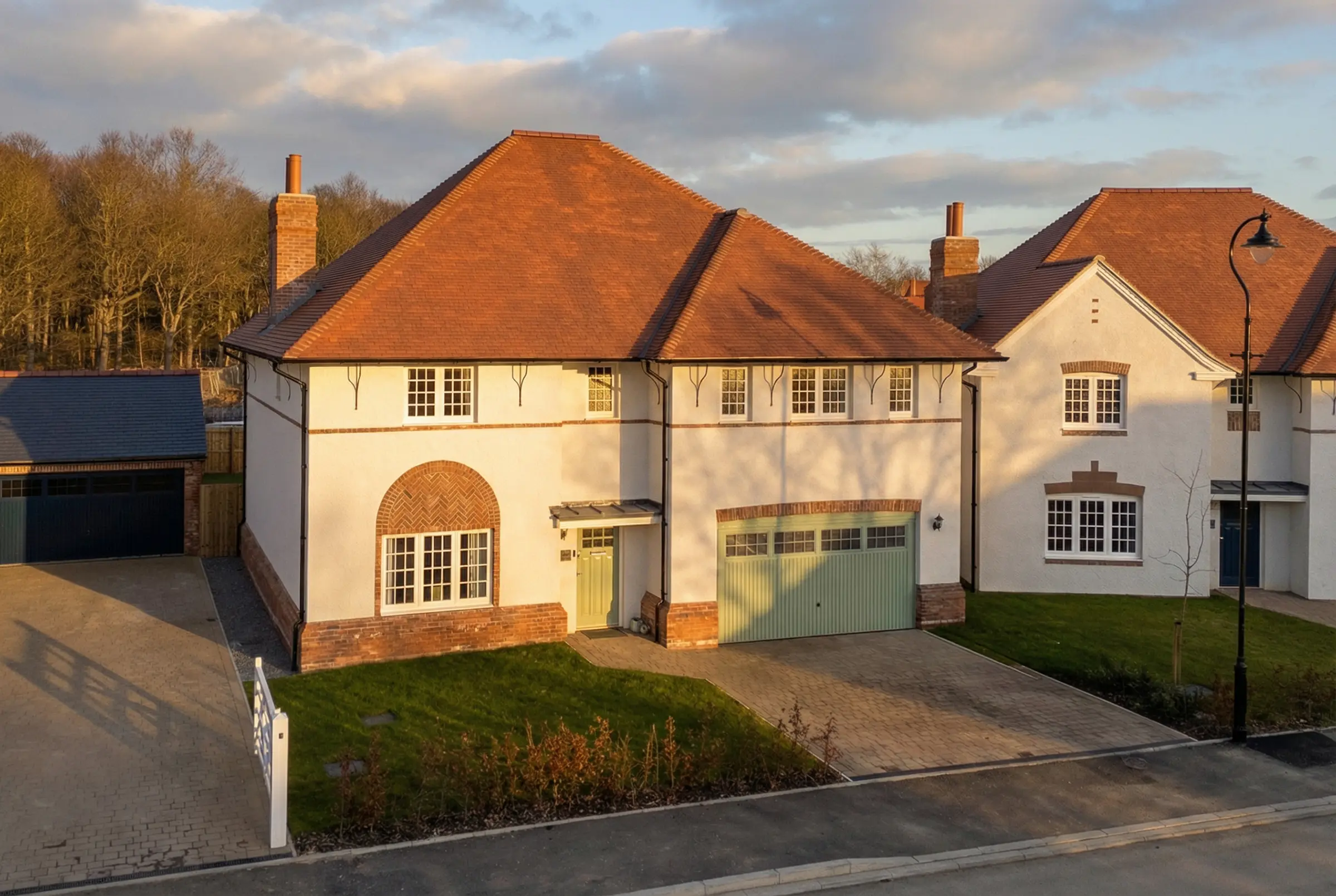 Clean white render house elevation with surgical lighting and estate emerald lawn detail.
